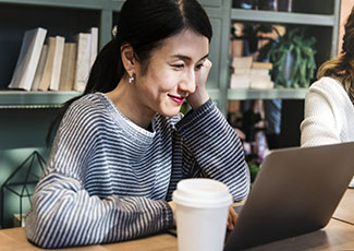 Asian woman in a cafe on her laptop