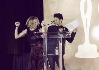 two women jumping for joy after winning award