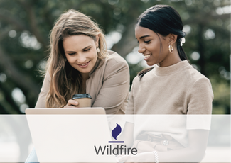 two women sit and look at a computer, with overlay of wildfire inc logo