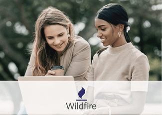 two women sit and look at a computer, with overlay of wildfire inc logo