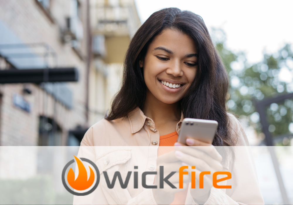 woman smiling at phone with wickfire logo overlay